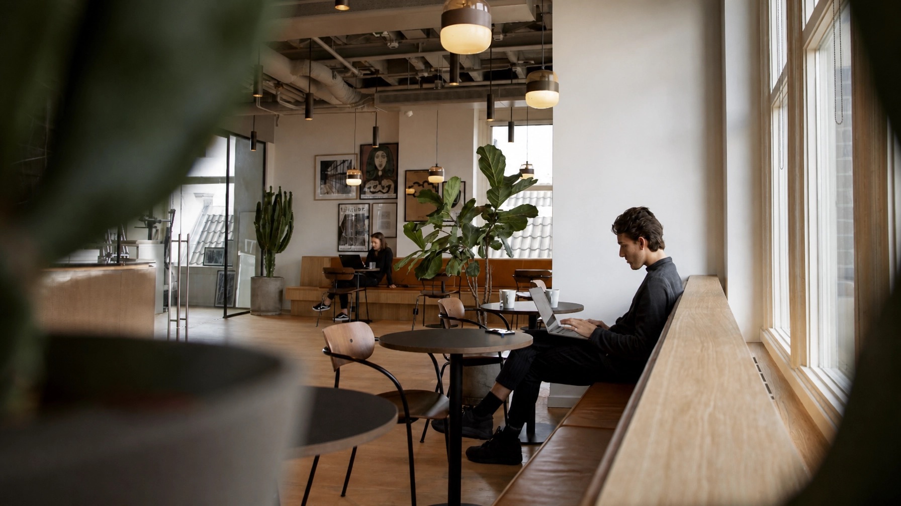 Remote professionals working on laptops in a bright coworking space
